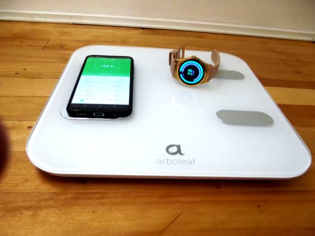 Arboleaf scale pictured with a smartwatch and a cellphone