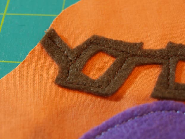 Sew pieces onto the front piece of the toy's body fabric.