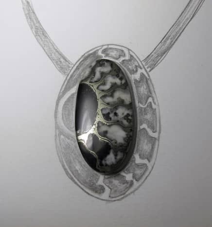 Lisa Barth sketches a rough setting and backplate design around the ammonite fossil to echo and extend its pattern onto the silver with syringe clay.
