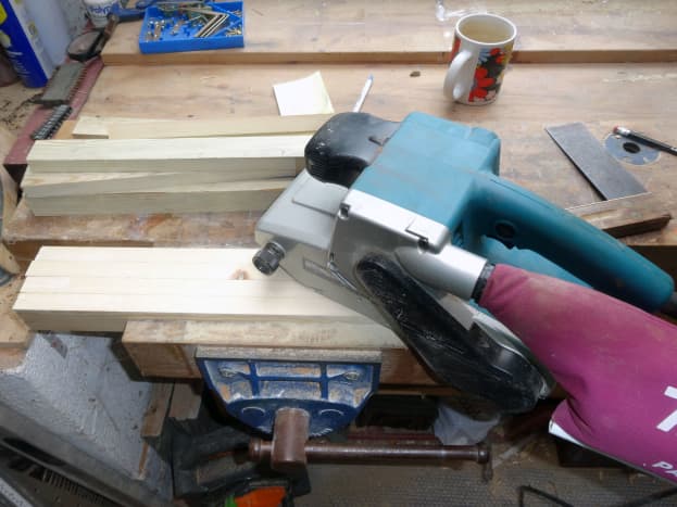 Belt sander to smooth down rough-cut roofing battens.