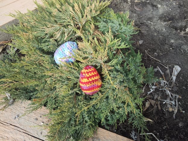 Here are a couple of crocheted Easter eggs brightening up a raised bed garden.