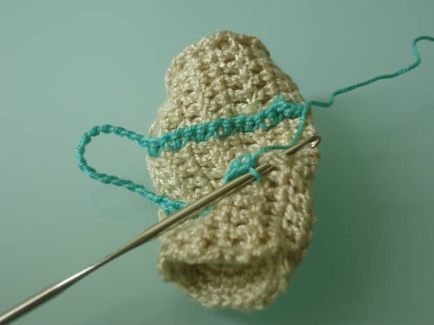 Crocheting through the dc post, sideways, and working 2 sc in each dc post. Here is my hook inserted through the next dc post.