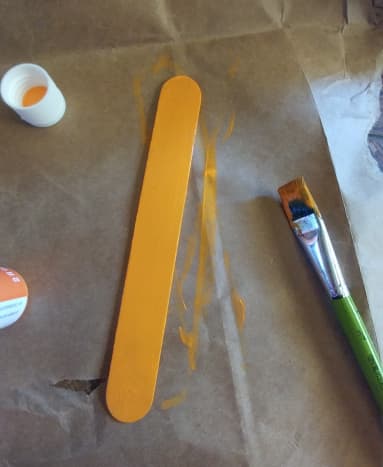 Popsicle stick painted orange.