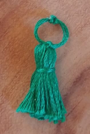 Tiny tassels can be made exactly as large ones, except downsized. This one is made without embelishments, strictly out of thread.