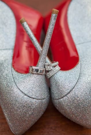 Gorgeous wedding rings on silver high heel shoes with red lining