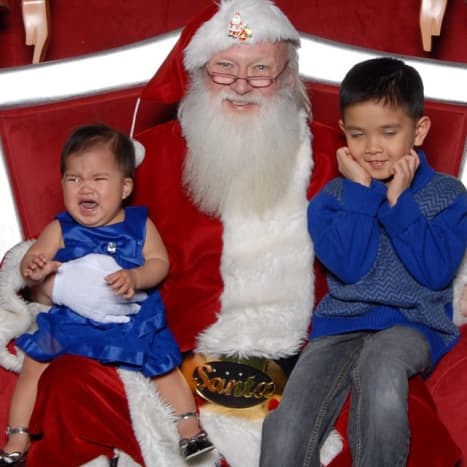 The older brother's expression is priceless, and Santa is taking pride in the terror he is inflicting.  Does Santa have a dark soul?