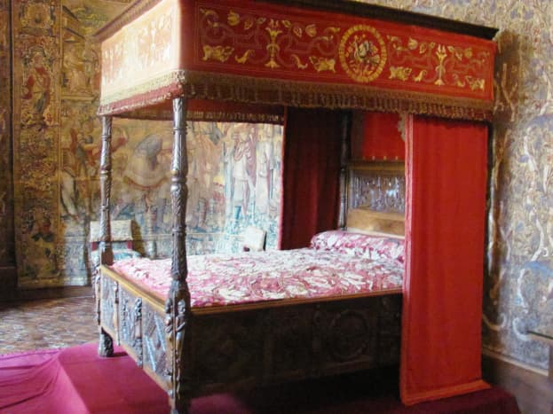 Catherine de' Medici's bedroom features rare Flanders tapestries, an exquisite wooden ceiling, and this four-poster Renaissance bed.