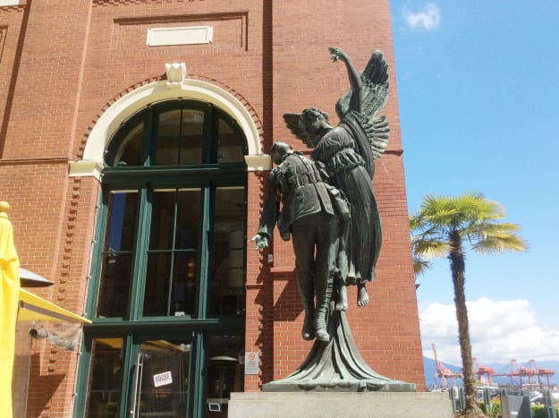 A view of the sculpture that shows the angel's raised hand and the missing wreath