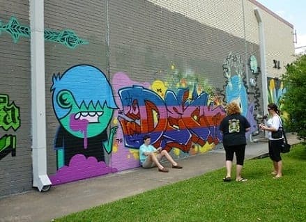People admiring graffiti murals across from Baldwin Park