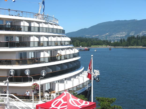 A cruise ship with part of Stanley Park in the background