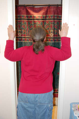 Place hands on door frame, with elbows even with shoulders, and lean into door opening.