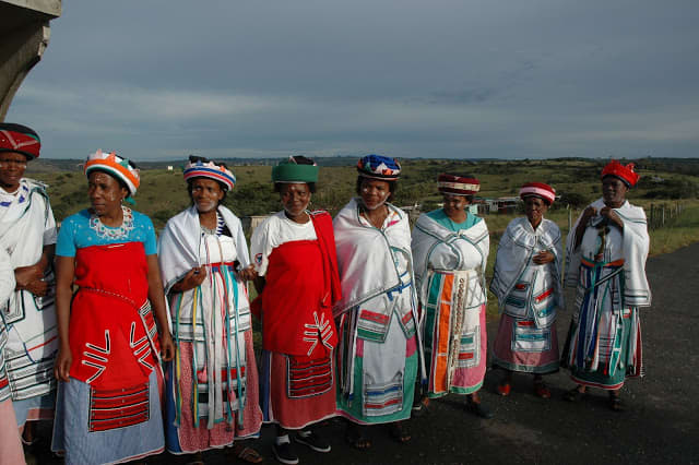 Xhosa ladies.It is important for women to look dignified at all times particularly if there is a cultural ritual. Women must cover their head at all times and have a scarf around their waist and have something to put on their shoulders. This is a sig