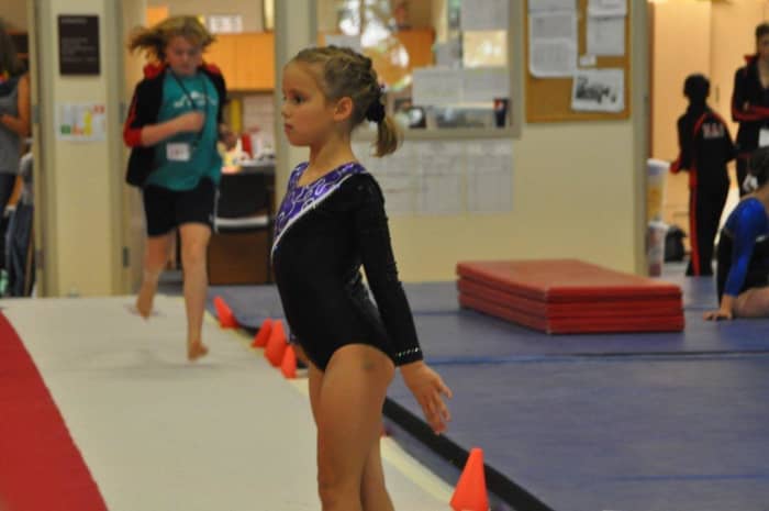 Gymnast at attention - awaiting start of Level 5 floor routine
