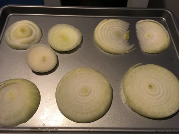 Slice an onion into thin slices and put them on a baking sheet. (I used a cookie sheet but something with higher sides is preferable since you'll be pouring liquid in the pan.)