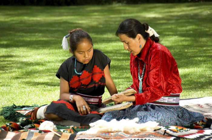 Navajo woman and girl, sharing culture.