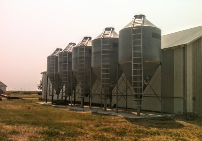 This row of 5 small vintage bins may not be especially attractive, but they function well. Several spokes and cross-bracing help stabilize the structure, which has a shorter tank and longer hopper than some.