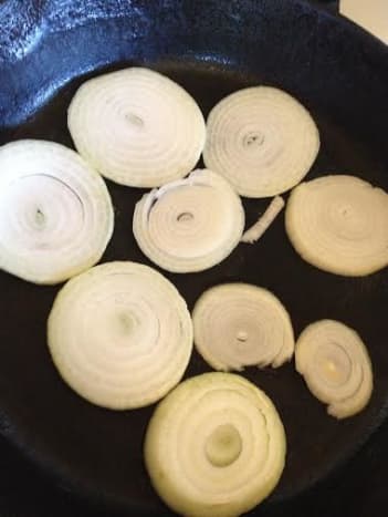 I use a heavy cast iron skillet. Put a layer of the onion down. This provides flavor as well as keeps the chicken from sticking to the pan.