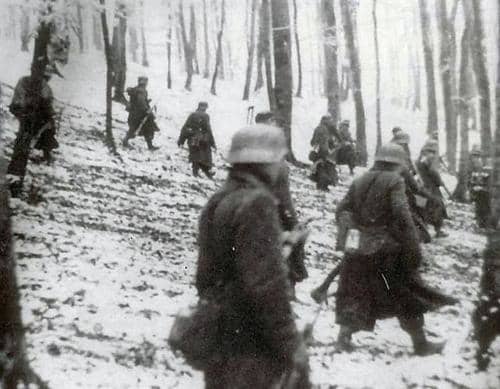 German troops cautiously approach American lines in the early morning hours of December 16, 1944.