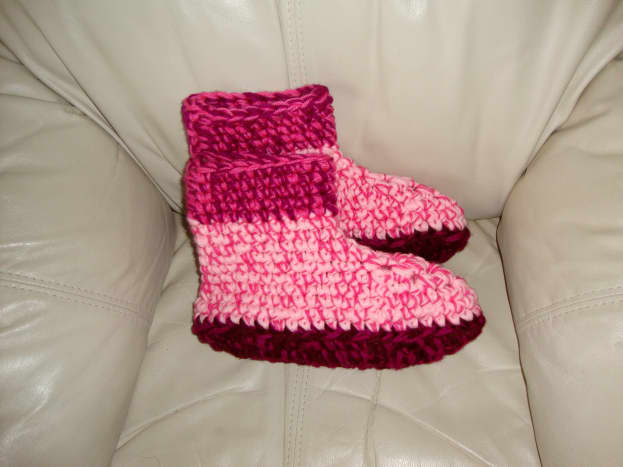 Pink slippers made with yarn and wool.