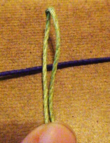 1.  Using two 90 inch hemp chords, one of blue and one of green, fold the green in half and place this folded loop overtop the center of the blue chord.