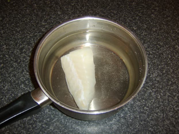 Cod fillet is briefly poached in water