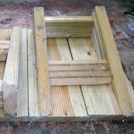 Underside view.  Boxed frame from decking offcuts with sloping sides, and decking on top.