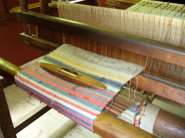 This loom with the spindle on top shows the work that goes into making patterned fabric.