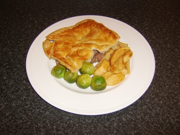 Traditional Scottish steak pie with chips and Brussels sprouts