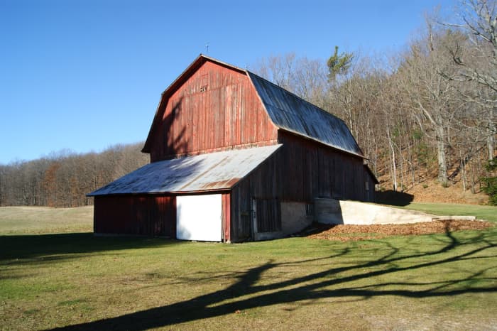 the traditional gambrel roof shape served a practical purpose. It increased the space for storing hay in the hay loft. 