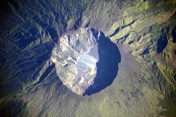 A detailed astronaut photograph depicting the summit caldera of the volcano Mount Tambora, Indonesia