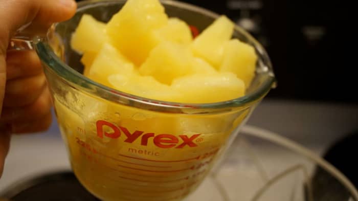 Add the pineapple chunks to a large pitcher or serving bowl.