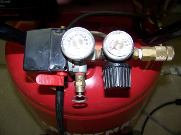 The pressure switch is the black box located to the left of the gauges. It turns the compressor motor on and off in order to maintain tank pressure.