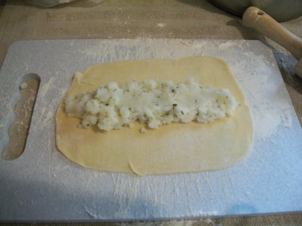 Roll out the dough into a thin disk. Place mashed potato filling in the center.