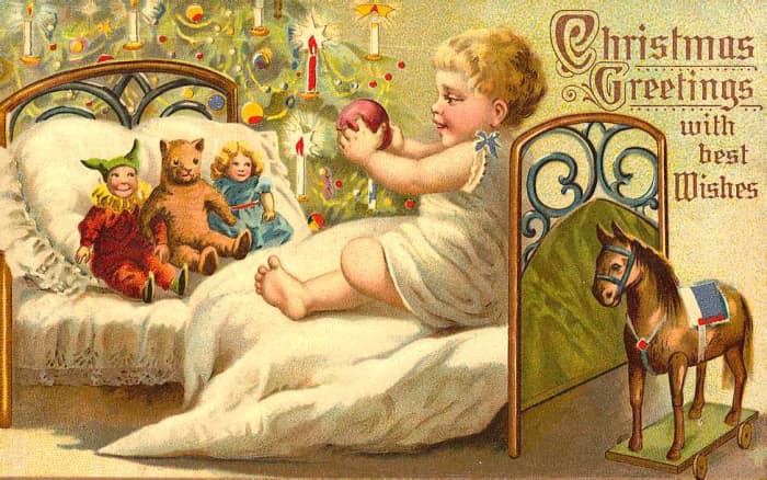 Vintage Christmas cards: Little child in bed with antique dolls