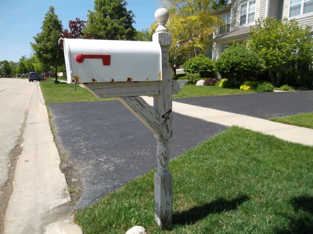 Use a pressure washer to strip off loose paint from a mailbox post