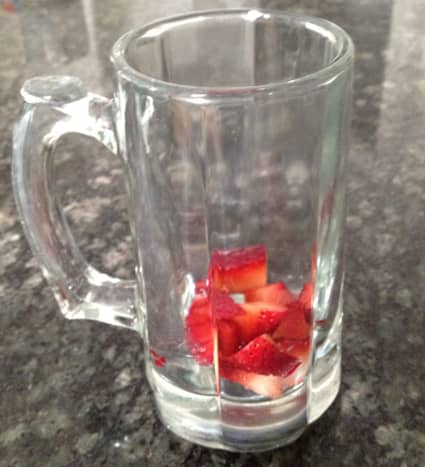 1. Fill bottom of clear glass or mug with diced strawberries.