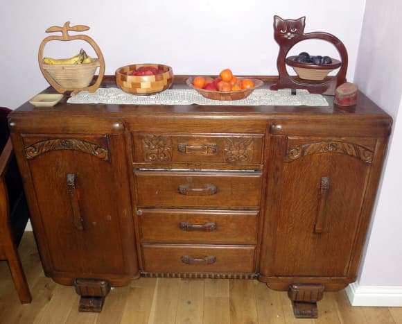 A family of wooden fruit bowls on the sideboard packed with fruit and nuts