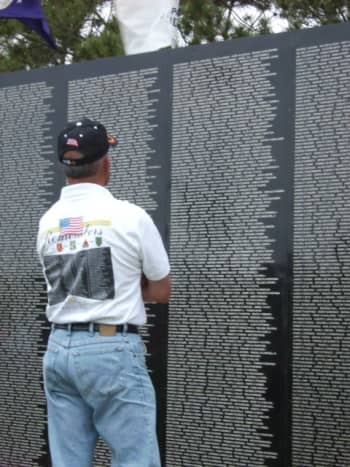 My husband at the wall viewing the names of his friends