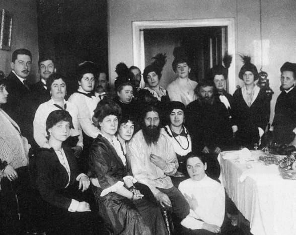 Rasputin surrounded by his family and friends his father is the man on his right. Note the telephone on the wall in the background.