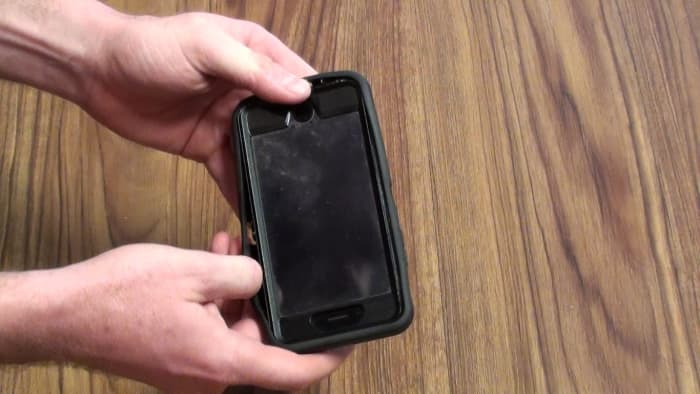 Slide your finger in the groove between the rubber outer shell and the hard plastic case inside of it. Work your finger around your iPhone to separate the out rubber shell, and then remove the rubber shell.