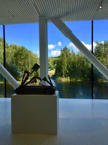 Large panoramic windows open up to lots of natural light and beautiful views of nature and the trout river, Randselva. In the foreground is Pedro Reyes's sculpture "Navaja Suiza VIII (Swiss Army Knife VIII)", 2014.