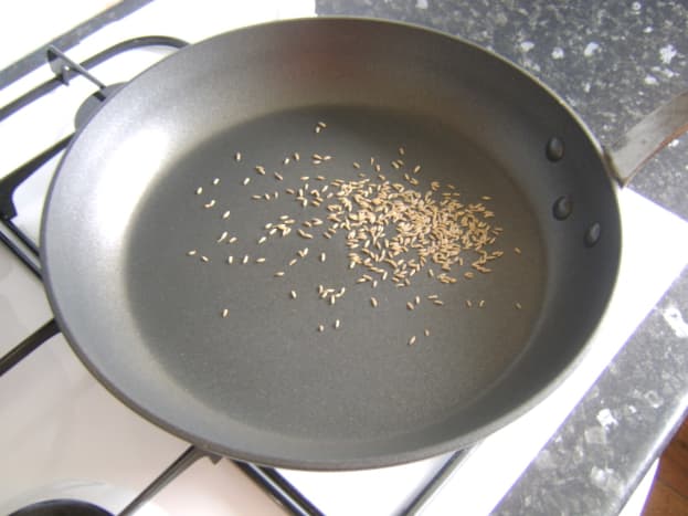 Cumin seeds are toasted in a hot, dry frying pan