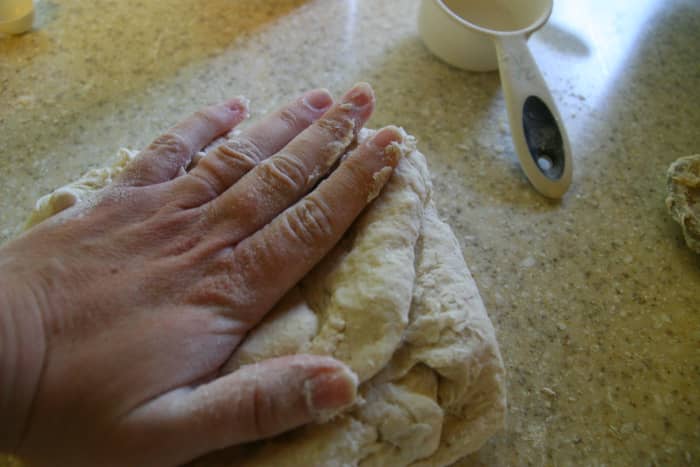 Place the dough ball on the counter. Press the dough out with your hand.