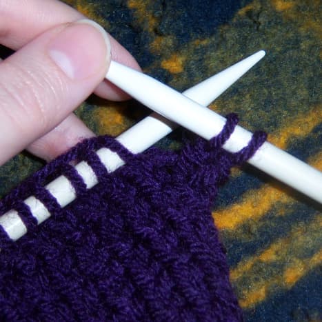 First, knit two stitches onto the working needle.