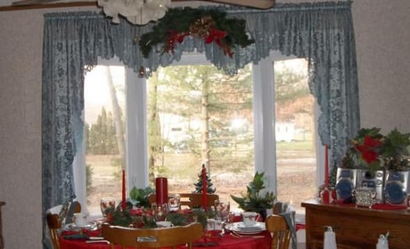 A simple swag centered over the curtain with no wall items to take away from the view.   The outside appears to be drawn into the room making it an elegant but cozy environment on a cold winter's day.