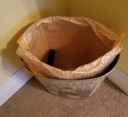 Lining a wastebasket with a mailing bag. You can fold the top down more if you don't want it showing above the edge of the wastebasket. 