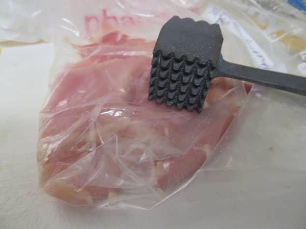 With a mallet, flatten the chicken thighs in a freezer bag