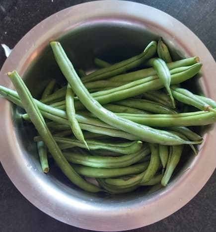Wash and trim the French beans. Remove the fibrous strings if any.
