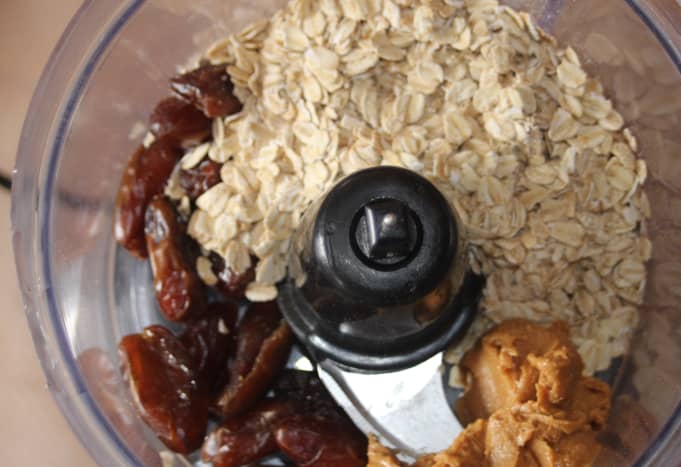 Add the oats, dates, peanut butter, and maple syrup to a food processor. 