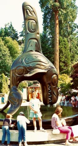 My niece standing under the Orca statue  in Stanley Park